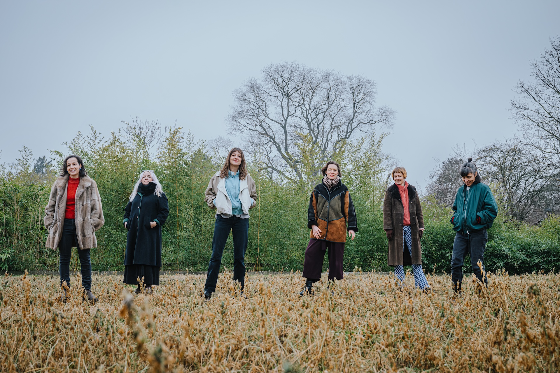 Stella Matko stehen auf einem Feld Katja Neubert, Nora Mona Bach, Charlotte Antony, Linda Grüneberg, Katharina Gahlert und Michal Auch von rechts nach links
